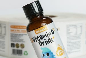 Waterproof pearlized film adhesive labels on cosmetic glass bottles, showing high-gloss finish and curved surface adhesion