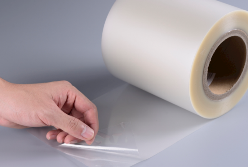 Hot‑water removal of removable transparent film label from plastic drink bottle