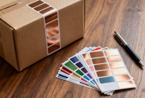 Assortment of GemmyLabel coated paper labels on a shipping box and as loose price tags on a wooden desk