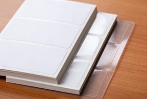 Different return address label materials including paper polyester and clear film used for custom mailing labels