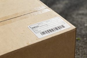 Weatherproof return address label applied on a shipping parcel demonstrating durable adhesive label for packaging