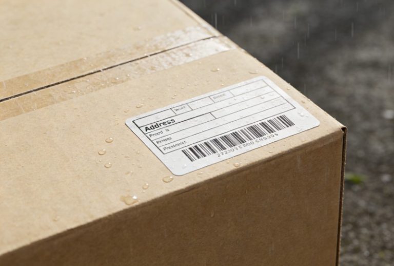 Weatherproof return address label applied on a shipping parcel demonstrating durable adhesive label for packaging